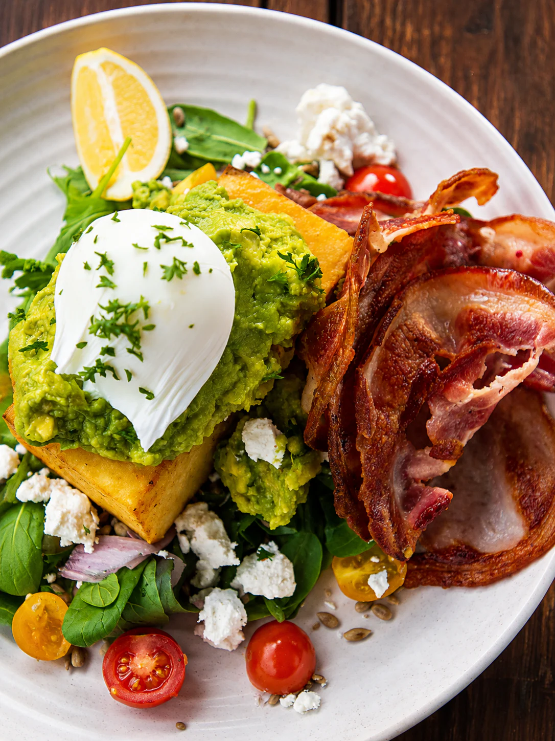 Brunch plate with avocado, bacon, feta and greens